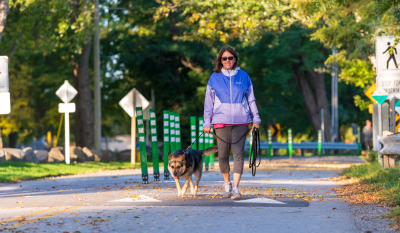 woman and a dog walking on the multi use path